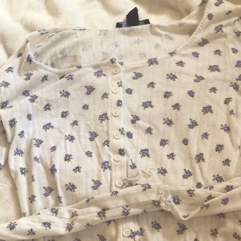 Dainty floral shirt with a unique texture to the touch and white accent buttons.